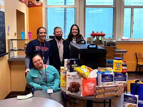 Students and staff of the Binghamton High School café pose with the donations from Visions