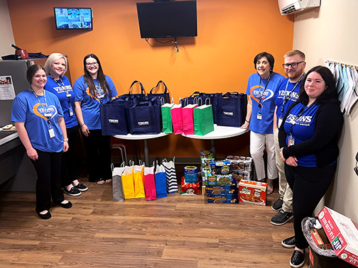 Visions employees from our Binghamton North, NY branch pose with the food and supplies gathered for their donation to the St. Mark's Episcopal Church Food Distribution Center.