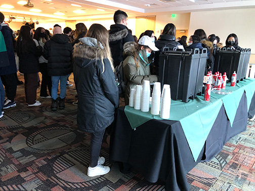 New Binghamton University students fill their cups with free hot cocoa and whipped cream, courtesy of Visions.