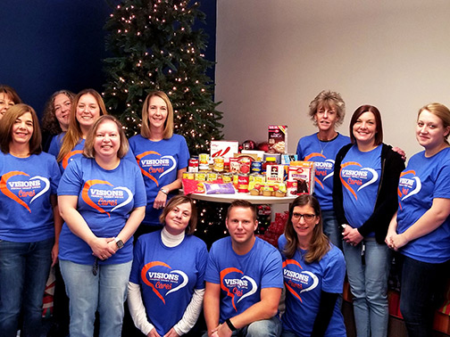 Visions FCU Central Lending Department posing with their food donations for St. Anthony's Food Pantry