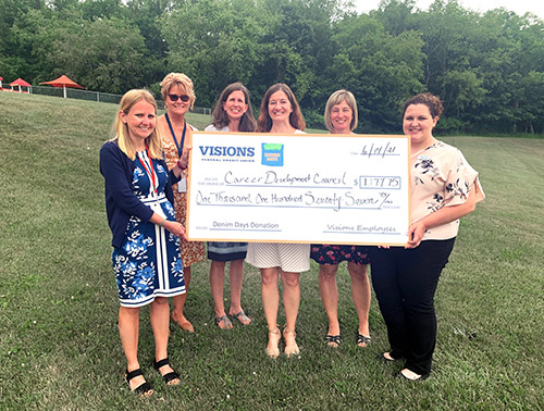 Visions employee, Jocelyn Bailey, presents the representatives of the Career Development Council with a jumbo ‘Denim Days' check for $1,177.75.