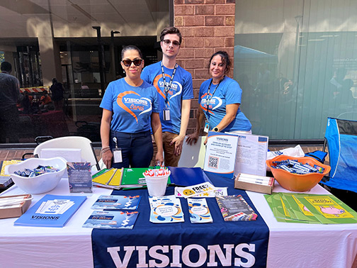 Pictured at the Visions table are Muhlenberg employees Raquel, Jadon, and Millie.