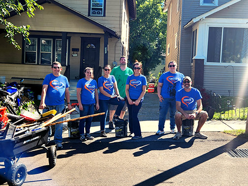 Six Visions employees standing in front of a driveway with various tools and equipment.