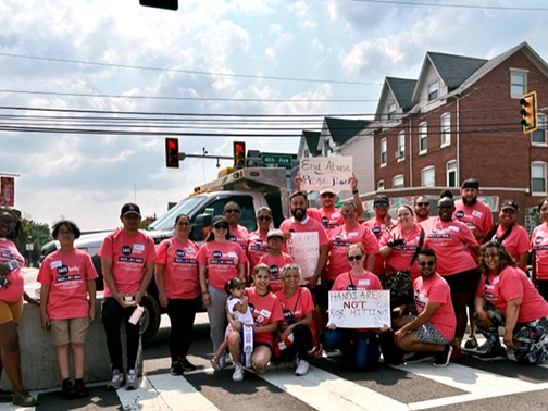 Visions employees in front of a pickup truck on a beautiful June day. The employees are in an empty intersection holding signs in support of the Safe Berks Walk.