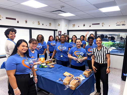 Smiling Visions volunteers ready to make bagged lunches for members of the community in need. Referee Tatiana stands ready to monitor the competition and ensure a fun time is had by all!
