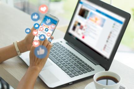 person on social media using their phone and laptop