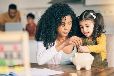 mother and daughter with piggy bank