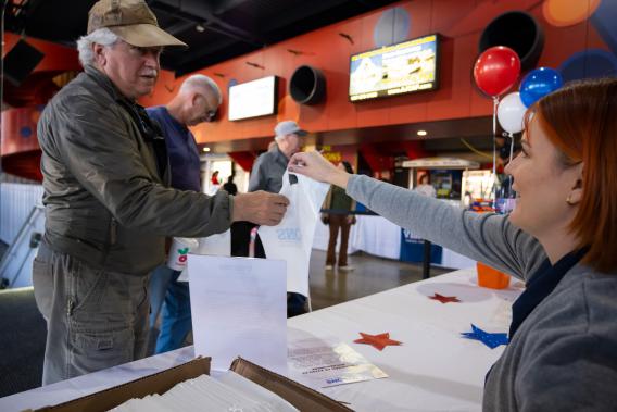 Veterans employee handing out bags at a booth.