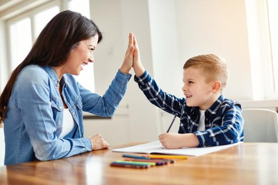 mom giving young son a high five
